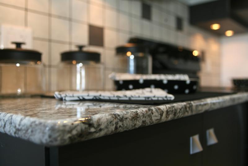 Granite countertops and nice hardware on the cupboards make the kitchen sleek. 