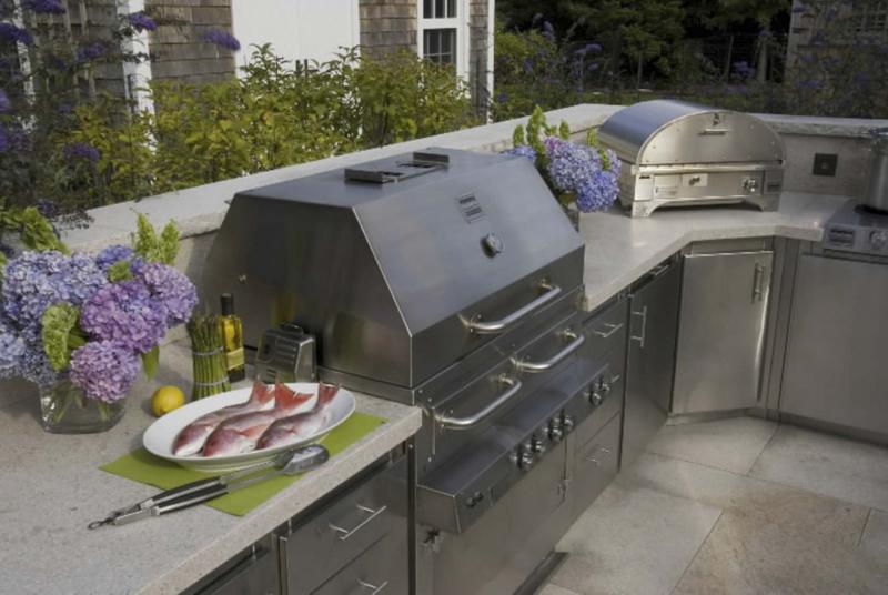 <p>MCT</p><p>This outdoor kitchen features a stainless-steel grill, pizza oven and cabinets that are easy to maintain. </p>