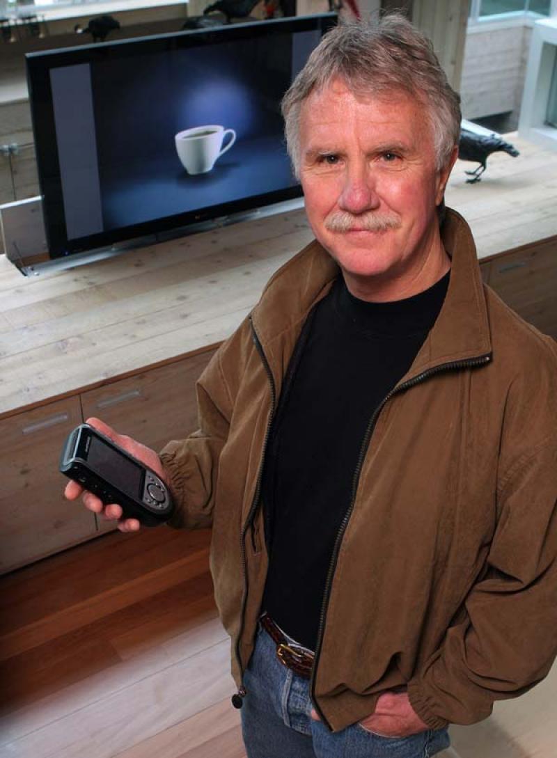 Bill McMahon demonstrates how his flat-screen TV disappears into the rear of his entertainment unit.
