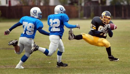 WAYNE GLOWACKI/WINNIPEG FREE PRESS In High School Football action Friday,   the  Oak Park  High Raiders  defeated the visiting  Fort Frances High School Muskies 26-17. Muskie  receiver Kevin Gemmell  manages to hold onto the ball while being chased Raiders #79 Kevin MacNeil and # 22  Kevin Cady . Sept 26 2003