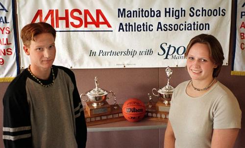 Sports - Paul Lodewyks, of the Dakota Lancers, and Marsha Murdock, of the Oak Park Raiders, hope their teams will take home the trophies (behind them), during the AAAA Provincial High School Basketball Championships. - Heather Hudak photo March 16, 1999
