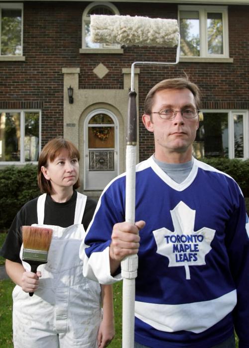 04/10/05 - WINNIPEG - Nancy and Al Walkey re-create the classic painting "American Gothic" with paint props in front of their home on Tuesday evening. With no NHL to root for, Al Walkey will be painting instead. Photo by Marianne Helm for the Winnipeg Free Press