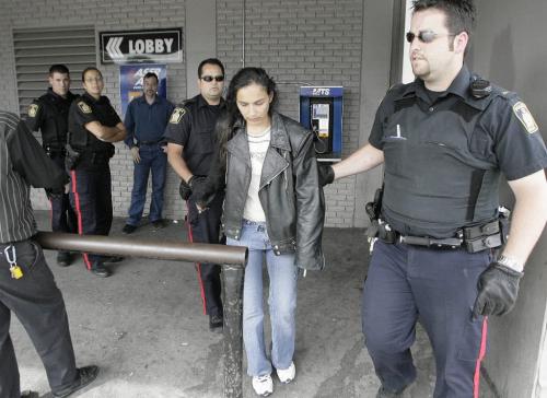 John Woods / Winnipeg Free Press / September 1  2006 - 060901 - Police remove a women from the Maryland Hotel after she allegedly assaulted manager Fred Schliephacke (rear/blue) Friday, September 1/06.  Hotel management called the Free Press when police were slow to respond after the women allegedly assaulted several people.