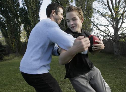 John Woods / Winnipeg Free Press / September 20, 2006 - 060920 - Twelve year old Gary Glays and Big Brother Michael Hofstatter play football in Gary's back yard Wednesday, Sept. 20/06.   They have been partnered in the Big Brother program for three years.  They are part of a volunteer drive for the organization.