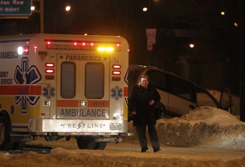 BORIS.MINKEVICH@FREEPRESS.MB.CA   BORIS MINKEVICH / WINNIPEG FREE PRESS 101202 A serious MVC at the Furmor and Dunkirk intersection sent at least one to hospital. Fire rescue crews had to use the jaws of life to pry open a mini van to extricate the crash victim. Accident occured around midnight. Westbound Furmor and northbound Dunkirk were closed down for quite some time. Woman in photo is not identified. She was in the ambulance for a while.