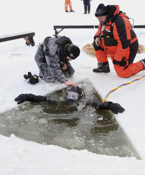 MIKE.DEAL@FREEPRESS.MB.CA 101211 - Saturday, December 11, 2010 - Members of the Canadian Amphibious Search Team prepare to go under the ice of the Red River Saturday to continue the search for six-year-old Nathaniel Thorassie who fell through the ice on the river last Saturday while playing with his brother. MIKE DEAL / WINNIPEG FREE PRESS