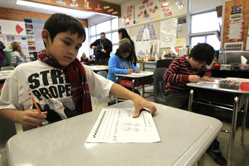 MIKE.DEAL@FREEPRESS.MB.CA 101214 - Tuesday, December 14, 2010 - Children in the grade four Ojibwe language class at Strathcona School. Ricky Henderson, 9, draws a mouse on a worksheet that will include its tracks and objibwe name waabigozhiish. MIKE DEAL / WINNIPEG FREE PRESS