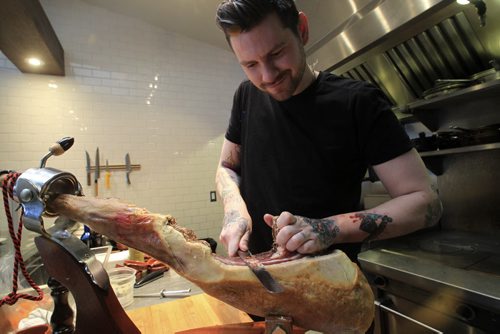 MIKE.DEAL@FREEPRESS.MB.CA 101215 - Wednesday, December 15, 2010 - Carolina Konrad and chef Adam Donelly in their Tapas restaurant Segovia on Stradbrook Avenue. In the photo chef Adam Donelly uses the jamon iberico de bellota. See Wendy Burke story. MIKE DEAL / WINNIPEG FREE PRESS