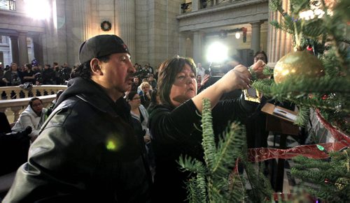 MIKE.DEAL@FREEPRESS.MB.CA 101221 - Tuesday, December 21, 2010 - A ceremony with families, friends and loved ones to honour missing and murdered Aboriginal women and girls. As part of the ceremony ornaments were hung on a special tree and traditional honour songs were performed. Wilford and Bernece Catcheway put up an ornament for their daughter Jennifer who went missing on her 18th birthday three years ago. MIKE DEAL / WINNIPEG FREE PRESS