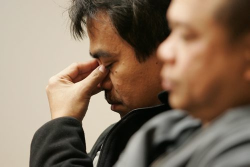 December 23, 2010 - 101223  -   Arnistito Gaviola (R) listens as Antonio Laroya wipes tears as his daughter speaks in his favour via speaker phone  at a press conference on Thursday, December 23, 2010 at the Broadway Disciples United Church in support of the Three Amigos, three migrante workers who face deportation. John Woods / Winnipeg Free Press