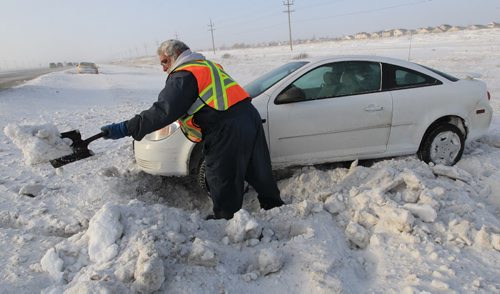 JOE.BRYKSA@FREEPRESS.MB.CA Local- ( standup photo) - Randy Darbell of CAA digs out a car that slid into the ditch on Hyw 101 South near St Annes Road Monday morning-Black ice and high winds caused dangerous driving conditions for motorists sending many slidding into the ditch- JOE BRYKSA/WINNIPEG FREE PRESS- Dec 27, 2010