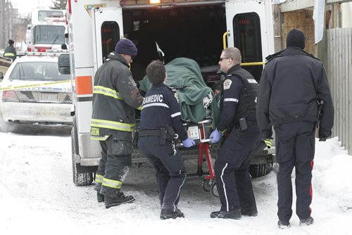 January 1, 2011 - 110101  - Emergency personnel remove a victim from the rear of 325 Manitoba Avenue on Saturday, January 1, 2011. John Woods / Winnipeg Free Press