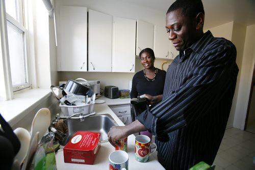 January 1, 2011 - 110101  - Haitian Syvelie Mesidor smiles as her husband Arisnel makes tea in their Winnipeg apartment on Saturday, January 1, 2011. Arisnel Mesidor brought his wife to Canada last year after the earthquake. Syvelie is one of 15,000 newcomers who came to Manitoba in 2010 - a new record. John Woods / Winnipeg Free Press