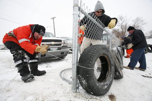 December 29, 2010 - 101229  -   Bill Hasiuk (L) and city crews build a fence and install tires to help protect sledders at Garbage Hill on Wednesday, December 29, 2010. John Woods / Winnipeg Free Press