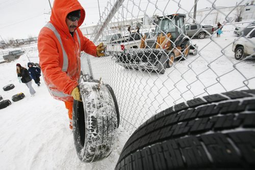 December 29, 2010 - 101229  -   Noah Whitford and city crews build a fence and install tires to help protect sledders at Garbage Hill on Wednesday, December 29, 2010. John Woods / Winnipeg Free Press