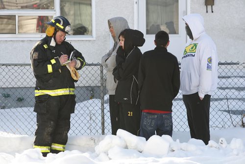 January 08, 2011 - 110108  -  Residents of 714 Flora talk to a fire investigator as firefighters work on extinguishing a fire at their house Saturday, January 8, 2011.    John Woods / Winnipeg Free Press