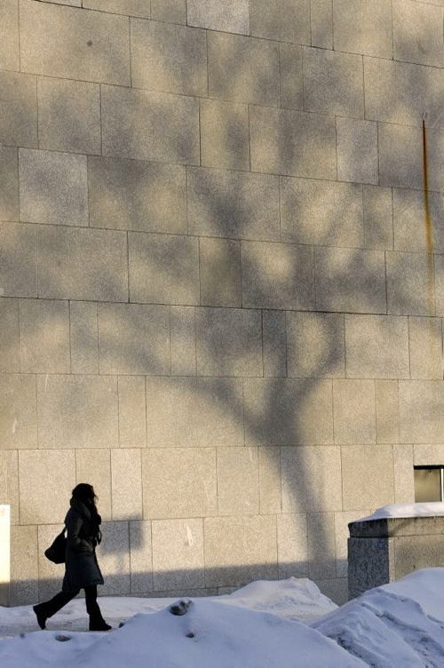 MIKE.DEAL@FREEPRESS.MB.CA 110111 - Tuesday, January 11, 2011 - A pedestrian walks past the WAG building which is catching late afternoon shadows of trees in downtown Winnipeg. MIKE DEAL / WINNIPEG FREE PRESS