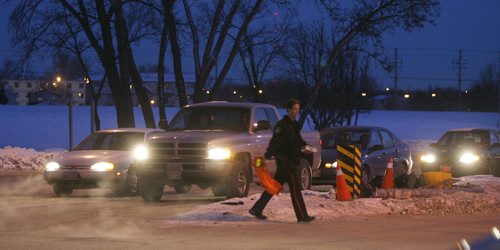 MIKE.DEAL@FREEPRESS.MB.CA 110111 - Tuesday, January 11, 2011 - A police officer crosses Pembina Hwy after a pedestiran was hit at the intersection with Bison Drive just before rush-hour traffic. MIKE DEAL / WINNIPEG FREE PRESS
