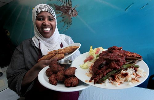 PHIL.HOSSACK@FREEPRESS.MB.CA 110112-Winnipeg Free Press Roda Guled, self admitted Owner, manager and dishwasher at Sal'Adar Kheyr restraunt holds an armfull of North Somali delecacies, Samosas, Falafel, and Salmon with Ochra....See Marion's tale