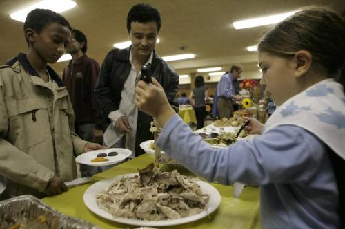 John Woods / Winnipeg Free Press / October 5, 2006 - 061005 -Juliana Barclay serves up some turkey to Guo Qing De from China at a Thanksgiving dinner put on for immigrants at the International Centre Thursday, Oct. 5/06.  The Girl Guides helped with fund raising and serving of the meal.