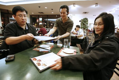 January 14, 2011 - 110113  -  Ziyang Lin, owner of Dim Sum Garden serves Raymond Lai and May Lee at his restaurant Friday, January 14, 2011. Fort Richmond has seen a increased migration of Chinese to the community. John Woods / Winnipeg Free Press