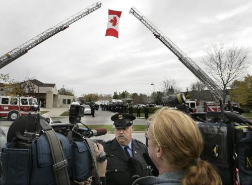 John Woods / Winnipeg Free Press / October 6, 2006 - 061006 - On Friday Oct. 6/06 Bruce Duncan, family friend and colleague of Morris Lawrence, speaks to media under an aerial honour salute at the funeral service of Lawrence who reportedly died of work related illness.