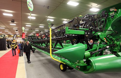 Brandon Sun 18012011 Visitors to Ag Days check out an extra long header on a John Deere combine at the Keystone Centre on Tuesday afternoon.  (Tim Smith/Brandon Sun)