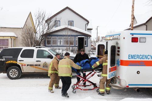 Brandon Sun 28012011 Brandon Fire and Emergency Services member load a patient into the back of an ambulance in front of 235 5th St. in Brandon on Friday after the patient was allegedly assaulted. One man was taken into custody at the home. (Tim Smith/Brandon Sun)