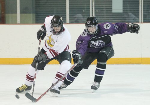 Brandon Sun 03022011 Kyle Johnston #26 of the Crocus Plainsmen and Conan Mickey #10 of the Vincent Massey Vikings battle for the puck during Westman High School Hockey League action at the Optimist Arena on Thursday evening. (Tim Smith/Brandon Sun)