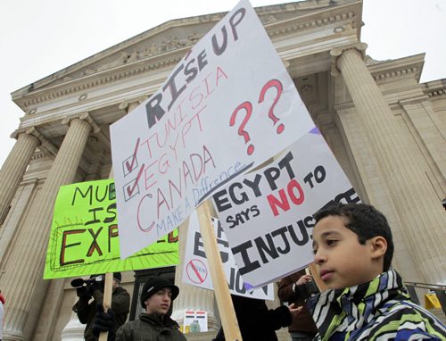 MIKE.DEAL@FREEPRESS.MB.CA 110205 - Saturday, February 05, 2011 - Local Egyptians gathered at the Manitoba Legislature to add their voice to the call for Egyptian President Hosni Mubarak to step aside. Ramy Frieg, 10 (right), carries a sign during the protest. His grandma, auntie and several cousins still live in Egypt. MIKE DEAL / WINNIPEG FREE PRESS