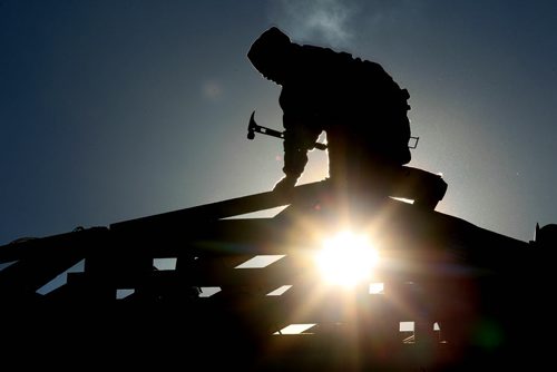 Ruth Bonneville Winnipeg Free Press Feb 10, 2011 Local, Construction workers are silhouetted against a bright sunny sky Thursday afternoon as they work on framing a roof in Bridgwater Forest (Waverly West) Thursday afternoon. FYI - Could be standup photo or could go along with photo of Manitoba Home Builders Association President Mike Moore also taken today for McNeills story on higher cost of new homes due to new building codes.