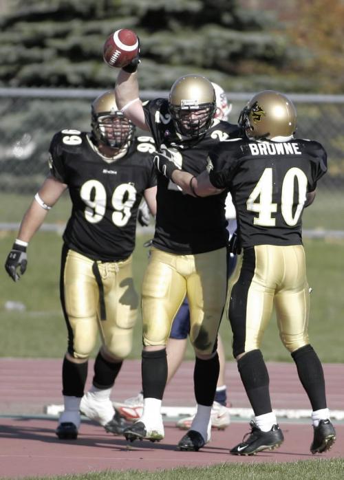John Woods / Winnipeg Free Press / October 14, 2006 - 061014 - U of Manitoba Bison's DL Justin Shaw(2) celebrates with Matt Harper (99) and Brady Browne (40) after he recovered a SFU fumble and ran it in for the TD at the U of Manitoba Saturday Oct 14/06.