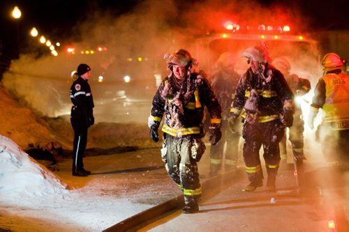 DAVID LIPNOWSKI / WINNIPEG FREE PRESS (February 25, 2011) These firefighter were covered in ice as firefighters battled a house fire at 35 Westwater Drive Friday night.