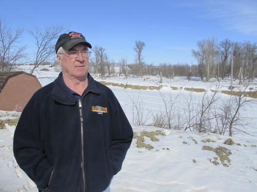 Melita Mayor Bob Walker stands on a dike raised by the province in 2009 at a cost of $500,000, with the Souris River in the background. He expects his town to be safe but said he's never seen the river this high at this time of year. BARTLEY KIVES/WINNIPEG FREE PRESS