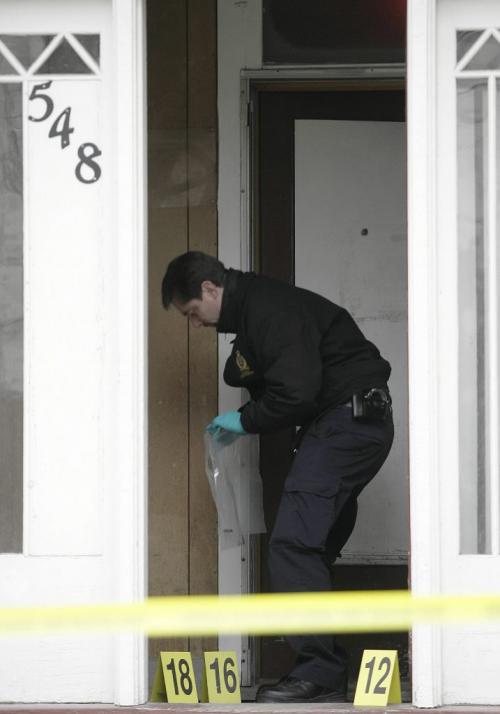 John Woods / Winnipeg Free Press / October 21, 2006 - 061021 - An identification officer collects evidence at the scene of Winnipeg's latest murder which occurred at 548 Spence early Saturday Oct 21/06.