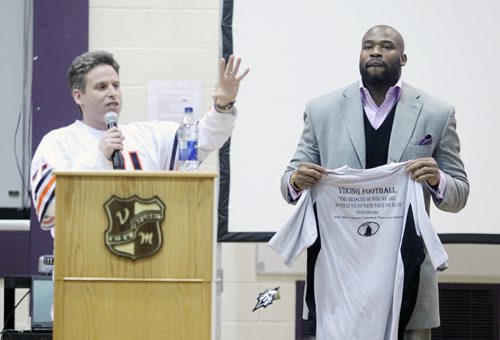 Brandon Sun 09032011 NFL player and Vincent Massey High School alumni Israel Idonije receives a Viking Football jersey from Vincent Massey teacher and football coach Kevin Grindey after addressing students from his former high school as well as visitors from J.R. Reid, Meadows and Linden Lanes schools in the gymnasium at VMHS on Wednesday afternoon. Idonije took questions from the audience and signed hundreds of autograph's for students in attendance. (Tim Smith/Brandon Sun)