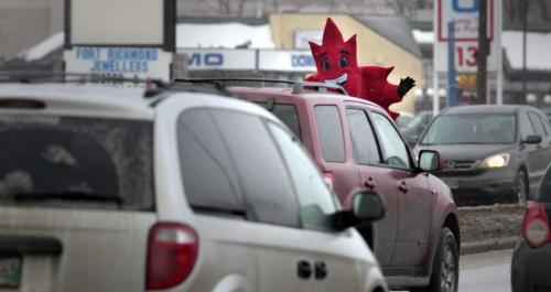 MIKE.DEAL@FREEPRESS.MB.CA 110317 - Thursday, March 17, 2011 - A mascot for Liberty Tax Services wearing a mapleleaf costume waves at passing vehicles during the snowstorm that swept through parts of Winnipeg today. MIKE DEAL / WINNIPEG FREE PRESS