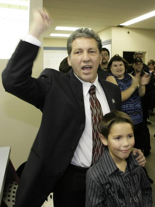 John Woods / Winnipeg Free Press / October 25, 2006 - 061025 - DAn Vandal with his son  Jerome raises his hand in victory at his campaign office after election results show that he defeated Magnifico Wednesday Oct 25/06.