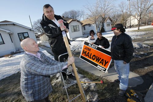 Winnipeg, Manitoba - 110326 - As a homeowner watches on Jim Maloway and his team Jason Schreyer (L), Clile Villa (C) and Pablo Herrera (R) put up signs in their Winnipeg riding  mere hours after a federal election was called on Saturday, March 26, 2011.   (JOHN.WOODS@FREEPRESS.MB.CA)