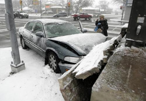 John Woods / Winnipeg Free Press / October 30, 2006 - 061030 - A woman stands outside her car after she collided with a commercial sign at the intersection of Ness and Ferry Monday Oct 30/06.   Winnipeggers had a hard time getting around today as snow fell for most of the day.