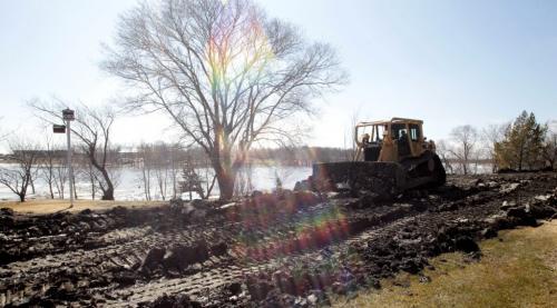 MIKE.DEAL@FREEPRESS.MB.CA 110406 - Wednesday, April 06, 2011 - Heavy machinery moves earth to build up the dike along the properties on the Pembina Trail just north of the 305 bridge in Ste. Agathe. See Bartley Kives story MIKE DEAL / WINNIPEG FREE PRESS