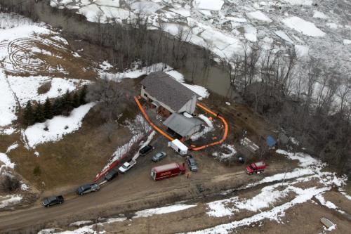 MIKE.DEAL@FREEPRESS.MB.CA 110408 - Friday, April 08, 2011 - The Red River flyover north of Winnipeg during the 2011 Flood. A house with emergency trucks on the east side of the Red River where an dike is under construction, north of Selkirk, MB. MIKE DEAL / WINNIPEG FREE PRESS