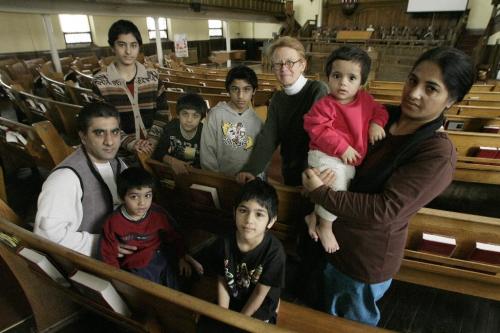 John Woods / Winnipeg Free Press / November 1, 2006 - 061101 - The Raza family who have taken sanctuary in the Cresent Fort Rouge United Church photographed with the church minister Rev. Barb Janes Wednesday Nov 1/06.  The Raza family are Kauser (mother), Hassan (father) and children (front row - LtoR) Massam, Farva, Sima, and in the back row (L to R) Rhubab, Zain, and Mohsin.