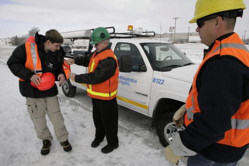 John Woods / Winnipeg Free Press / November 1, 2006 - 061101 - Bill Porter, Corporate Safety Officer for Manitoba Hydro, assists grade 9 student Colby Gurica with his safety equipment during a demonstration of safety wear at Sisler High School Wednesday Nov 1/06.   Colby's father Chris Gurcia, a lineman for MB Hydro watches on.