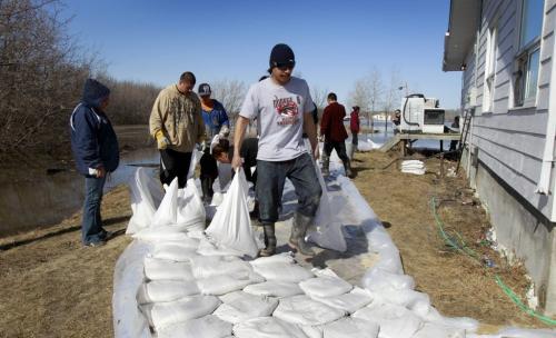 WAYNE.GLOWACKI@FREEPRESS.MB.CA  Volunteers make a sandbag dike around the home of Pam and Arnold Flett on the northern part of the Peguis First Nation Community after flooding from the Fisher River. Melissa Martin story Winnipeg Free Press April 14  2011