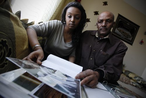 Winnipeg, Manitoba - 110418 - Iftu Hargaaya (24) and her father Juhar look at family photos in their Winnipeg home on Monday, April 18, 2011. Iftu Hargaaya's brother Fewaz (26), who was travelling in Ethiopia, has been arrested and has been in prison for the last three weeks. They have not spoken to him and are asking the Canadian government to step in.(JOHN.WOODS@FREEPRESS.MB.CA)