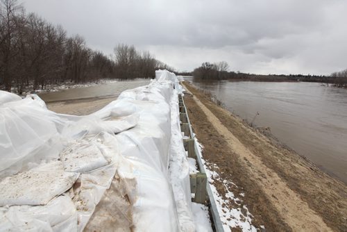 Brandon Sun 18042011 Sandbags create a dyke along the campground road in Spruce Woods Provincial Park at the edge of the swollen Assiniboine River on Monday. Workers were busy on Monday fighting the floodwaters at the Seton Bridge where Highway 5 crosses the Assiniboine in the park.  (Tim Smith/Brandon Sun)