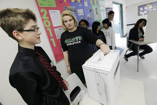 Winnipeg, Manitoba - 110428 - As other Elmwood High School students wait to vote Taylor Myers casts her vote as Deputy Returning Officer Julian Olesky (L) looks on in a corridor of the school in Winnipeg Thursday, April 28, 2011.  (JOHN.WOODS@FREEPRESS.MB.CA)