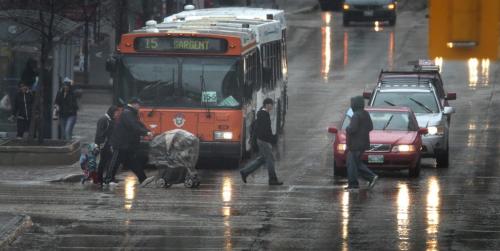 MIKE.DEAL@FREEPRESS.MB.CA 110430 - Saturday, April 30, 2011 - Pedestrians cross Portage Ave. during the downpour this afternoon. MIKE DEAL / WINNIPEG FREE PRESS
