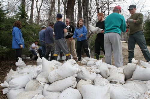 JOE.BRYKSA@FREEPRESS.MB.CA  Local- ( See   Sandy's   story)-  Rm Cartier- Volunteers sandbag a home on Golden Oak Cove in the RM of Cartier Sunday afternoon- Rising waters from the flooding Assiniboine River has put 40 homes in the area at risk of flooding- JOE BRYKSA/WINNIPEG FREE PRESS- May 08, 2011